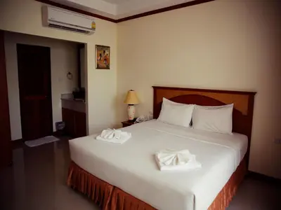 a bedroom with a large white bed with two towels on it at The Orchid House - SHA Extra Plus in Kata Beach