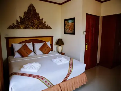 a bedroom with a bed with two white towels on it at The Orchid House - SHA Extra Plus in Kata Beach