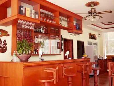 a bar with wooden bar stools in a restaurant at The Orchid House - SHA Extra Plus in Kata Beach