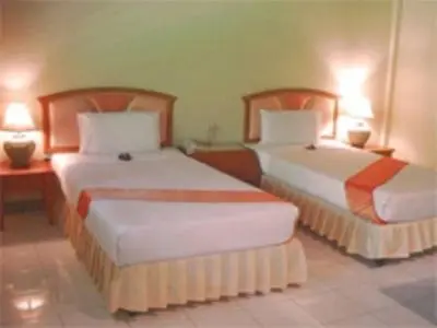 two beds in a hotel room with two lamps at Phuket Golden Sand Inn - SHA Extra Plus in Karon Beach