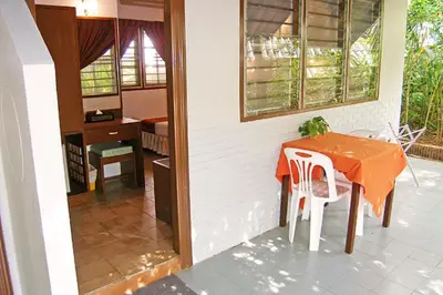 a dining room with a table and a desk at Phuket Golden Sand Inn - SHA Extra Plus in Karon Beach