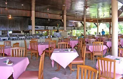 a restaurant with tables and chairs with pink table cloth at Phuket Golden Sand Inn - SHA Extra Plus in Karon Beach