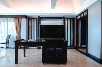 a living room with a television and a desk at C & N Resort and Spa - SHA Extra Plus in Patong Beach