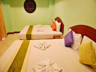 two beds in a hotel room with towels at Baan SS Karon in Karon Beach
