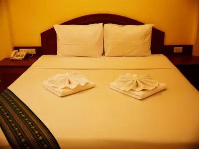 a bedroom with a bed with two towels on it at Baan SS Karon in Karon Beach