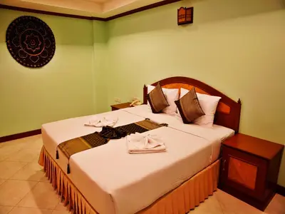 a bedroom with a large bed with white sheets at Baan SS Karon in Karon Beach