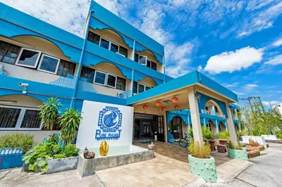 a blue building with a sign in front of it at Pure Phuket Residence in Phuket Town