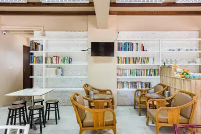 a room with chairs and tables and bookshelves at Pure Phuket Residence in Phuket Town