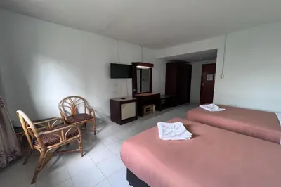 a room with two beds and a chair and a desk at Pure Phuket Residence in Phuket Town