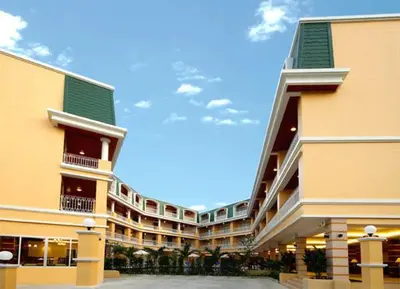 a large yellow building with a green roof at Kalim Resort in Patong Beach