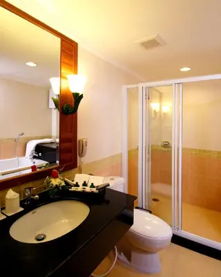 a bathroom with a toilet and a sink and a shower at Kalim Resort in Patong Beach