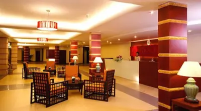 a lobby with chairs and tables in a building at Kalim Resort in Patong Beach