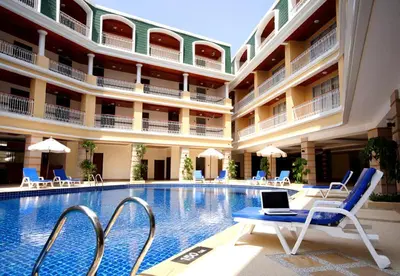 a hotel swimming pool with a laptop on a chair at Kalim Resort in Patong Beach