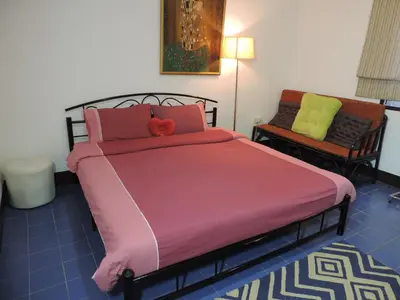 a bedroom with a large bed and a chair at Blue Paradise Residence in Rawai Beach