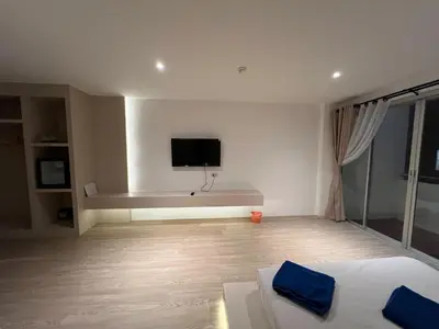 a living room with a couch and a tv on the wall at Keep Aonang in Ao Nang Beach