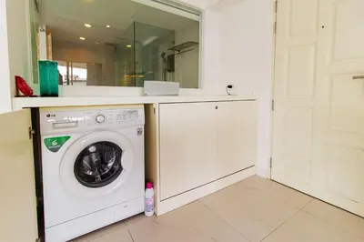 a laundry room with a washing machine and a mirror at Heritage Condominium - Patong Beach in Patong Beach