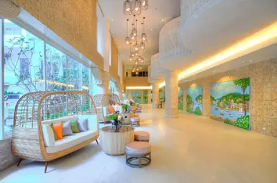 a lobby with a large room with chairs and tables at Heritage Condominium - Patong Beach in Patong Beach
