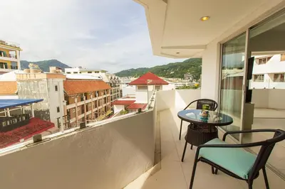a balcony with a table and chairs and a view at Heritage Condominium - Patong Beach in Patong Beach