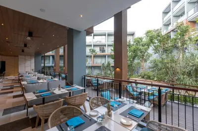 a restaurant with tables and chairs on a balcony at The Nature Phuket in Patong Beach
