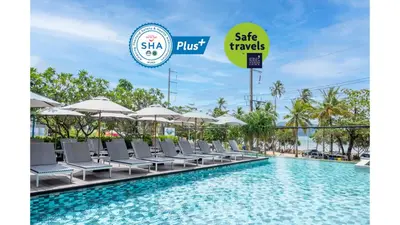 a pool with chairs and umbrellas at a resort at The Nature Phuket in Patong Beach