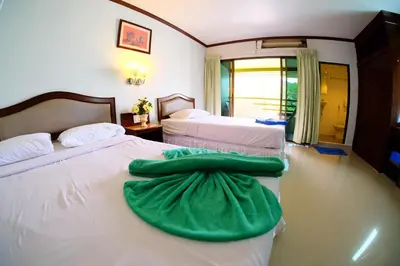 two beds in a hotel room with green sheets at P.K. Mansion in Ao Nang Beach