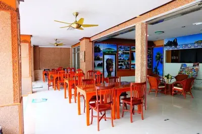 a dining room with red chairs and wooden tables at P.K. Mansion in Ao Nang Beach