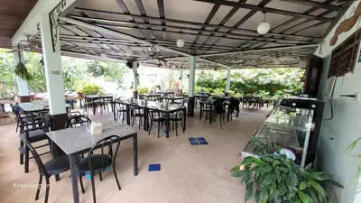 an empty restaurant with tables and chairs and tablesearcher at Sabai Resort in Ao Nang Beach
