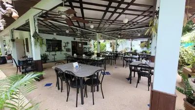 a dining area with tables and chairs in a restaurant at Sabai Resort in Ao Nang Beach
