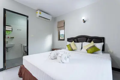 a bedroom with a large white bed with towels on it at Amorn Mansion in Ao Nang Beach