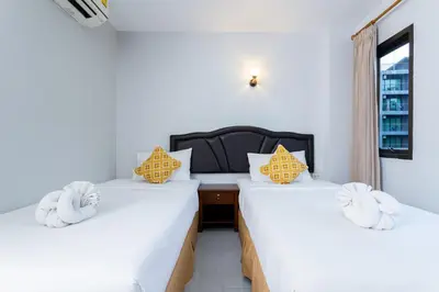 two beds in a room with white sheets at Amorn Mansion in Ao Nang Beach