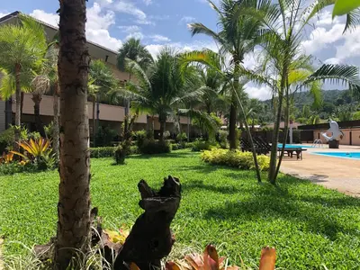a statue of a dog sitting in the grass near a resort at Maleedee Bay Resort in Ao Nang Beach