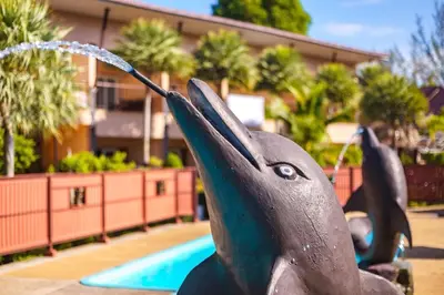a statue of a dolphin drinking water from a fountain at Maleedee Bay Resort in Ao Nang Beach