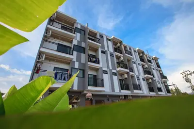 a tall building with a green plant in front of it at Be Live Residence in Thalang