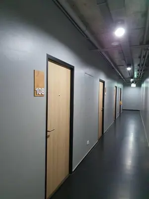 a hallway with a row of doors in a building at Be Live Residence in Thalang