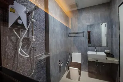 a bathroom with a shower and a toilet and a sink at Be Live Residence in Thalang