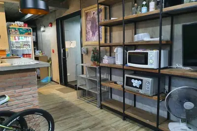 a kitchen with a counter and a microwave on a shelf at Be Live Residence in Thalang