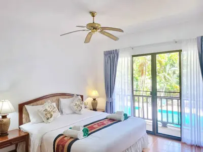 a bedroom with two beds and a large window at Kata Interhouse Resort by Haii Collection in Kata Beach