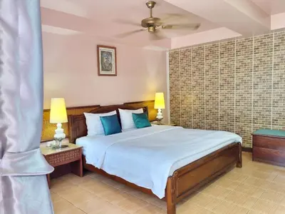a bedroom with a large bed with blue pillows at Kata Interhouse Resort by Haii Collection in Kata Beach