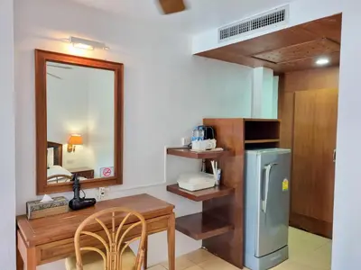 a kitchen with a table and a refrigerator at Kata Interhouse Resort by Haii Collection in Kata Beach