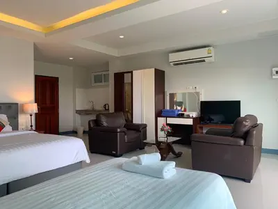 a bedroom with a bed and two chairs and a television at Da Bungalows in Kata Beach