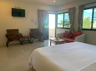 a bedroom with a bed and a couch and chairs at Da Bungalows in Kata Beach