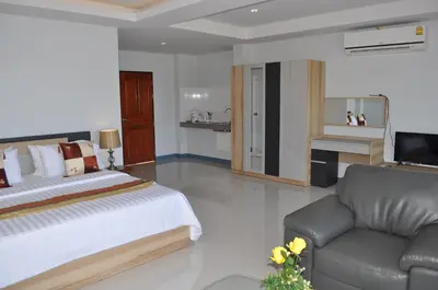 a bedroom with a bed and a couch and a television at Da Bungalows in Kata Beach