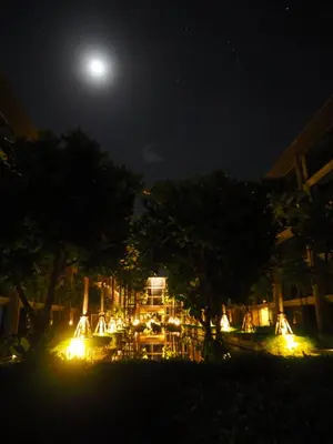 a view of a restaurant at night with a full moon at Baan Mai Khao in Mai Khao Beach