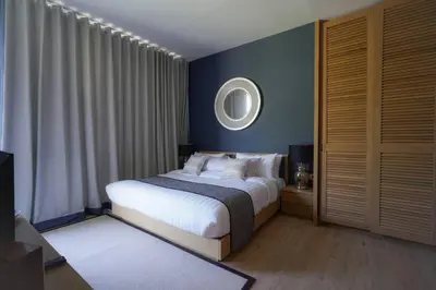 a bedroom with a bed and a mirror on the wall at Baan Mai Khao in Mai Khao Beach