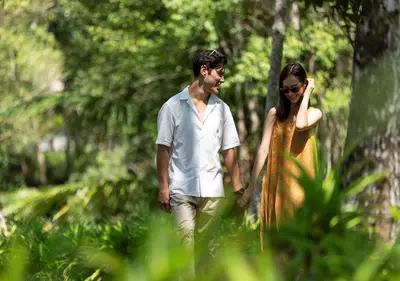 a man and a woman walking through a forest at Dusit Thani Krabi Beach Resort in Klong Muang Beach