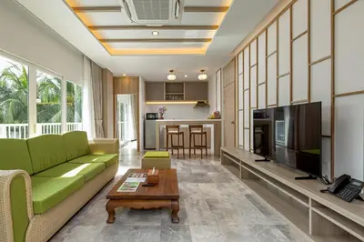 a living room with a green couch and a table at Phunawa Resort Phuket Karon Beach in Karon Beach