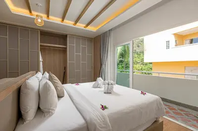 a bedroom with a large bed with flowers on it at Phunawa Resort Phuket Karon Beach in Karon Beach