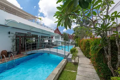 a bridge over a swimming pool in a villa at Phunawa Resort Phuket Karon Beach in Karon Beach