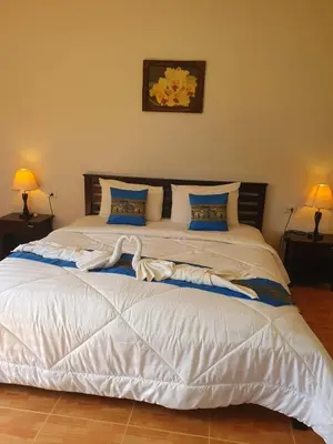 a bedroom with a large white bed with two lamps at Groovy Bungalows in Ao Nang Beach