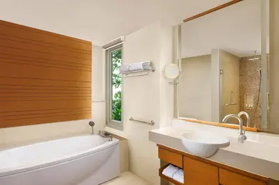 a bathroom with a tub and a sink and a mirror at The Westin Siray Bay Resort & Spa, Phuket in Phuket Town